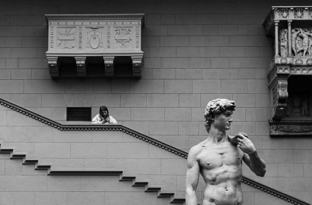 Monochrome urban scene featuring a statue and classical architecture.
